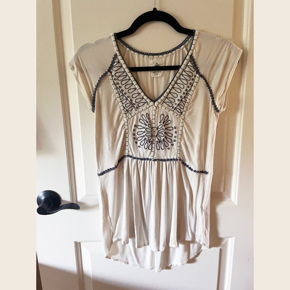 Cream cap sleeve top with blue embroidery